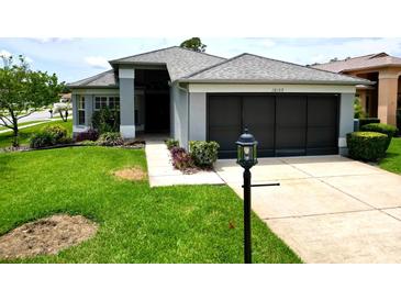 Charming single-story home featuring a well-manicured lawn and a two-car garage, creating a welcoming curb appeal at 18109 Webster Grove Dr, Hudson, FL 34667