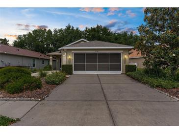 Charming home featuring a well-kept lawn, two-car garage, and welcoming curb appeal at 261 Rochester St, Spring Hill, FL 34609