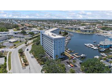 Stunning aerial view of waterfront condo building with boat docks and beautiful blue waters and surrounding community at 4939 Floramar Ter # 902, New Port Richey, FL 34652