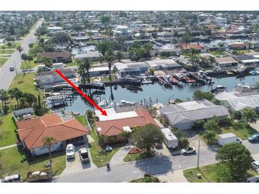 Waterfront property with a private dock, mature landscaping, and tile roof at 5008 Forecastle Dr, New Port Richey, FL 34652