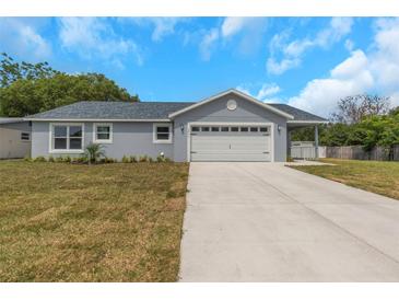 Charming single-story home featuring a two-car garage, landscaped yard and covered front porch at 5214 Idlewild St, New Port Richey, FL 34653