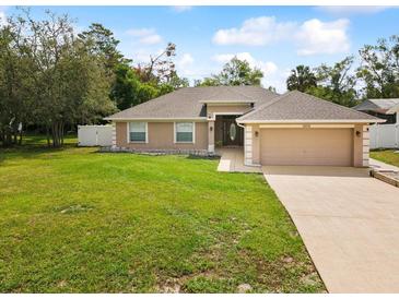 Charming single-story home featuring a well-manicured lawn and two-car garage at 6076 Shiprock Ave, Spring Hill, FL 34608