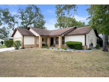 Charming one-story home featuring a well-maintained front yard and classic architectural details at 6490 Pine Meadows Dr, Spring Hill, FL 34606