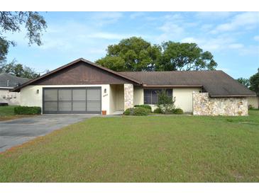 Charming single Gathering home featuring a two-car garage and quaint stone accents at 13425 Bonita Ave, Spring Hill, FL 34609