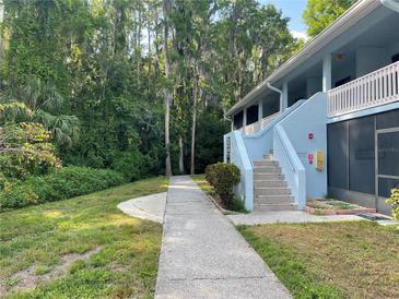 Charming exterior of a light blue condo building surrounded by lush greenery at 1983 Abrico Dr # H-9, Lutz, FL 33558