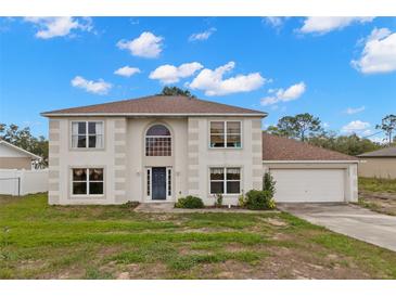 Charming two-story home with a well-maintained lawn, attached garage, and welcoming blue front door at 4148 Landover Blvd, Spring Hill, FL 34609