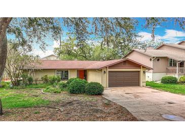 Charming single-story home featuring a brown roof, two-car garage, and front yard landscaping at 4420 Marine Pkwy, New Port Richey, FL 34652
