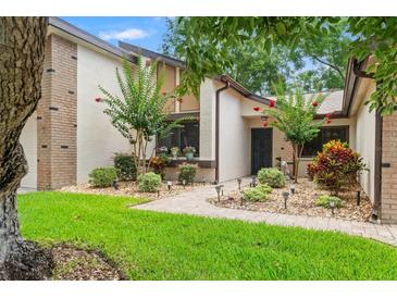 Charming single-story home with a well-manicured lawn, garden beds, and a brick pathway leading to the front entrance at 7512 Heather Walk Dr, Weeki Wachee, FL 34613