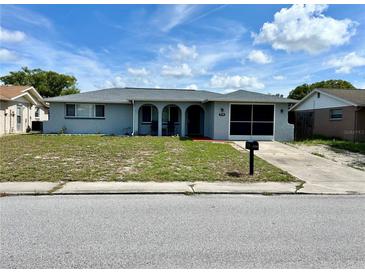 Charming single-story home with arched entry and a well-maintained lawn at 7719 Gaston Dr, Port Richey, FL 34668