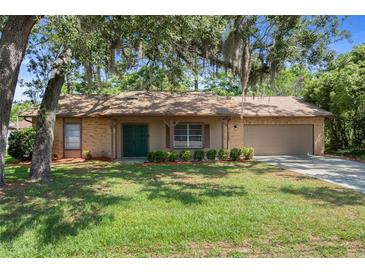 Charming single-story home featuring a well-maintained lawn and a covered front porch entrance at 8431 Spring Hill Dr, Spring Hill, FL 34608