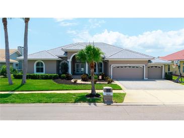 Charming single-story home with a manicured lawn, three-car garage, and inviting curb appeal at 9810 Compass Point Way, Tampa, FL 33615