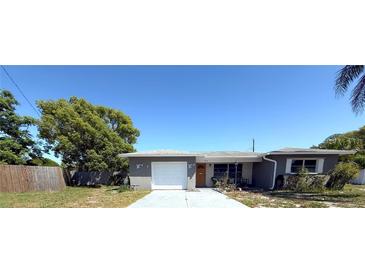 Charming single-story home featuring a well-maintained yard and attached single car garage at 10431 Syringa Ct, Port Richey, FL 34668