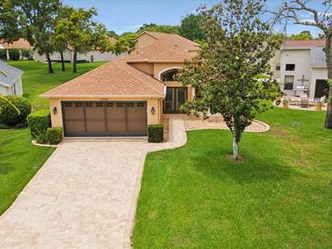 Charming single-story home featuring a tile roof, paver driveway, and mature landscaping at 11350 Copley Ct, Spring Hill, FL 34609
