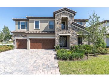 Stunning two-story home boasts a stone facade, three-car garage, and meticulously landscaped front yard at 3767 Dragonfly Trl, Odessa, FL 33556