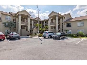 Condo building exterior featuring assigned parking, multiple stories, staircases, and neutral paint at 4575 Whitton Way # 1132, New Port Richey, FL 34653