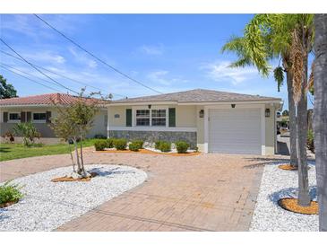 Charming single-story home featuring a brick driveway, stone accents, and well-manicured landscaping at 5045 Pelican Dr, New Port Richey, FL 34652