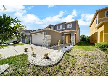 Charming two-story home featuring a well-manicured lawn and a two-car garage at 6222 Cherry Blossom Trl, Gibsonton, FL 33534