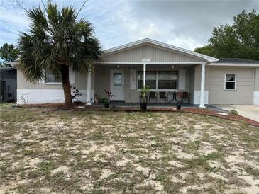 Charming single story home with front porch, neutral paint, and a beautiful palm tree at 7535 Christina Ln, Port Richey, FL 34668
