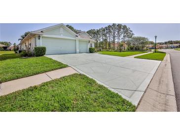 Large driveway leads to a well-maintained home with a spacious two-car garage at 11389 Mcnally Dr, Spring Hill, FL 34609