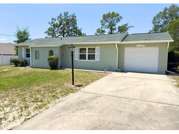 Charming single-story home with a well-maintained front yard and attached one car garage at 13180 Lawrence St, Spring Hill, FL 34609