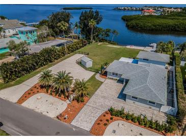 Stunning waterfront property with lush landscaping and a private beach at 1620 Sea Breeze Dr, Tarpon Springs, FL 34689