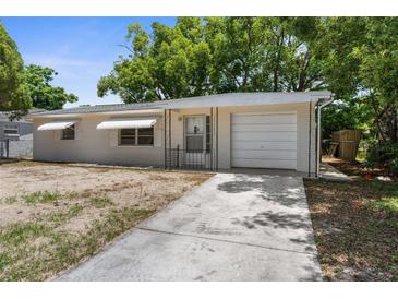An updated single-story home with a light exterior, attached garage, and newly poured concrete driveway at 4520 Blanche St, New Port Richey, FL 34652