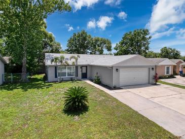 Charming single-story home featuring a well-maintained lawn and attached two car garage at 7979 Avenal Loop, New Port Richey, FL 34655