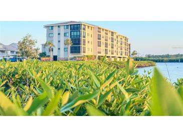 Beautiful exterior view of a waterfront condo building with lush greenery at 8211 Brent St # 836, Port Richey, FL 34668