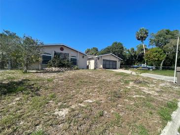 Charming single-story home with mature landscaping and an attached garage at 8711 Jolly Roger Dr, Hudson, FL 34667