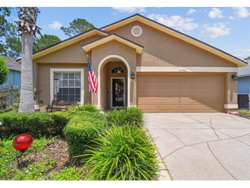 Charming single-story home with a manicured lawn, covered entry, and attached two-car garage at 11752 Wheatfield Loop, Hudson, FL 34667