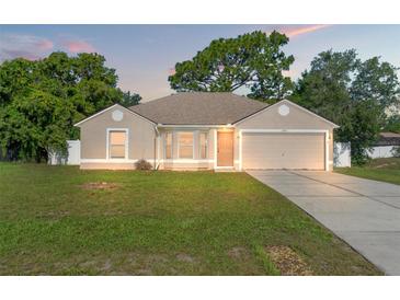 Charming single-story home with a well-maintained lawn and mature trees at 13935 Coronado Dr, Spring Hill, FL 34609
