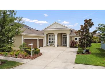 Beautiful single-story home with a well-manicured front yard and a three-car garage at 16697 Courtyard Loop, Land O Lakes, FL 34638