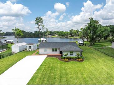 Charming lakeside home features manicured lawn, updated roof, and picturesque water views at 18102 Spencer Rd, Odessa, FL 33556