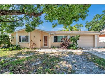 Charming single-story home featuring a cozy front porch and a well-maintained lawn with mature landscaping at 4025 Stratfield Dr, New Port Richey, FL 34652