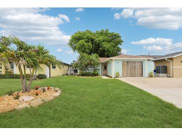 Charming single-story home with a well-manicured lawn and tropical landscaping at 4942 Blue Heron Dr, New Port Richey, FL 34652