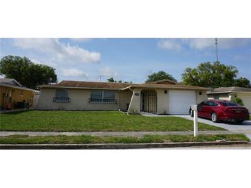 Charming single-story home with a well-manicured lawn, front door gate and a cozy, inviting curb appeal at 5636 Dolores Dr, Holiday, FL 34690