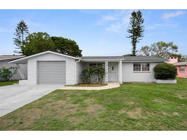 Charming single-story home featuring a well-maintained lawn and an attached garage at 7735 Farmlawn Dr, Port Richey, FL 34668