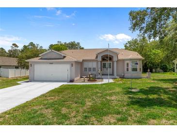 Charming single-story home featuring a well-manicured front yard and attached two-car garage at 8382 Christopher Ln, Weeki Wachee, FL 34613