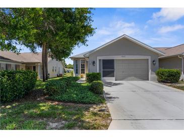 Charming home with a two-car garage, well-maintained lawn, and beautiful landscaping at 9407 Burnam Dr, Weeki Wachee, FL 34613