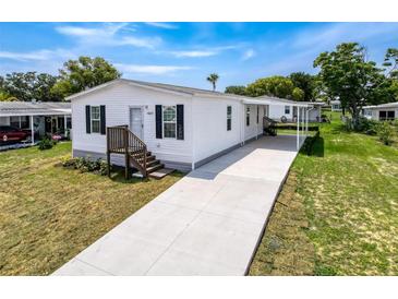 Charming single-story home featuring a covered carport and a well-maintained lawn at 16037 Brookridge Blvd, Brooksville, FL 34613