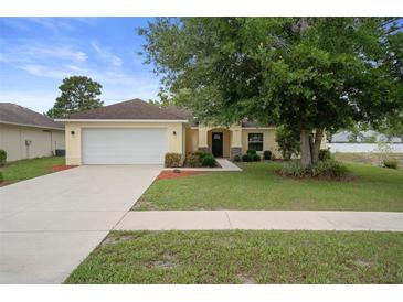 Well-maintained home with a two-car garage and a lush front yard at 3631 Celebration Dr, Brooksville, FL 34604