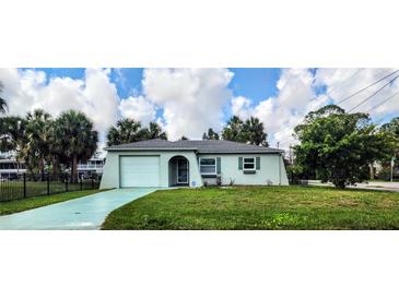 Charming single-story home features a one-car garage, well-manicured lawn, and lush, mature landscaping at 5447 Quist Dr, Port Richey, FL 34668