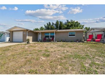 Charming single-story home with a brick facade, front lawn, and attached one car garage at 7830 Ilex Dr, Port Richey, FL 34668