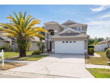 Two-story home with a white garage door, a palm tree, and well-maintained lawn at 8526 Hawbuck St, Trinity, FL 34655