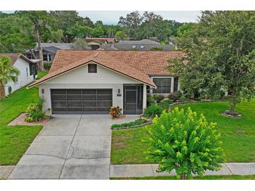 Charming single-story home with brick accents, mature landscaping, and a two-car garage at 8700 Wind Mill Dr, New Port Richey, FL 34655