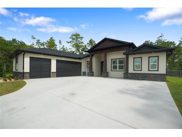 Spacious single story home featuring a three car garage and craftsman-style architecture at 10380 Yellow Hammer Rd, Weeki Wachee, FL 34614