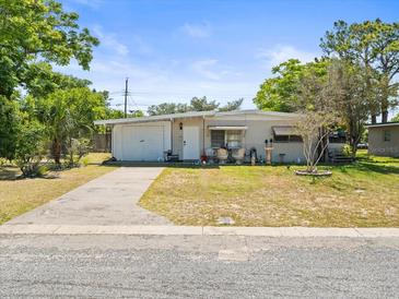 Charming single-story home with a well-maintained lawn and inviting front porch seating area at 5045 Grand Blvd, New Port Richey, FL 34652
