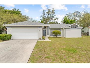 Charming single-story home with a well-maintained lawn and a two-car garage at 5087 Oyster Ct, Spring Hill, FL 34607