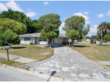 Charming single-story home with a spacious driveway and well-established trees in the front yard at 5154 Allamanda Dr, New Port Richey, FL 34652