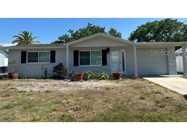Charming single-story home featuring a well-manicured lawn and attached garage at 6406 Stone Rd, Port Richey, FL 34668